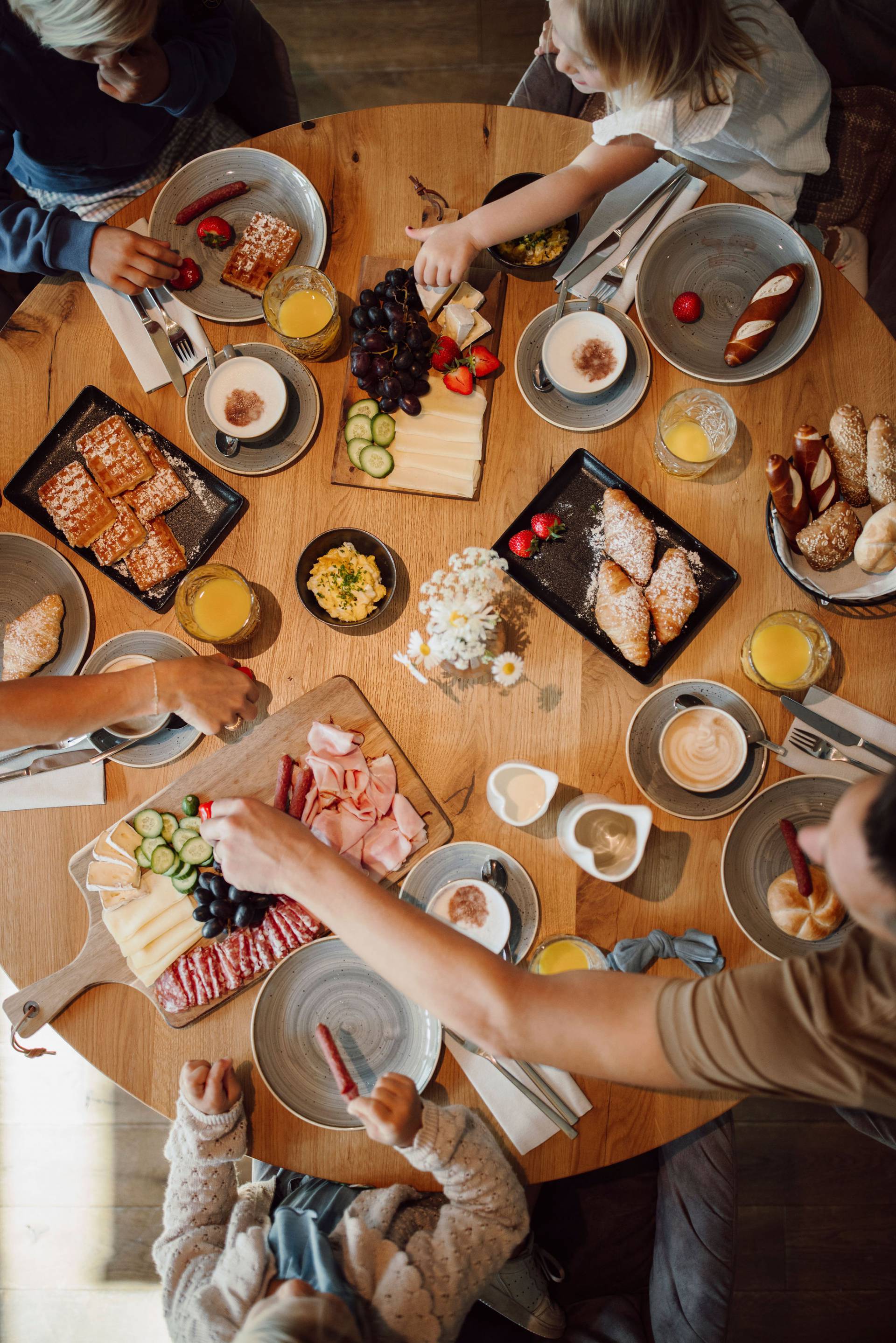 Draufsicht Familie am runden gedeckten Frühstückstisch