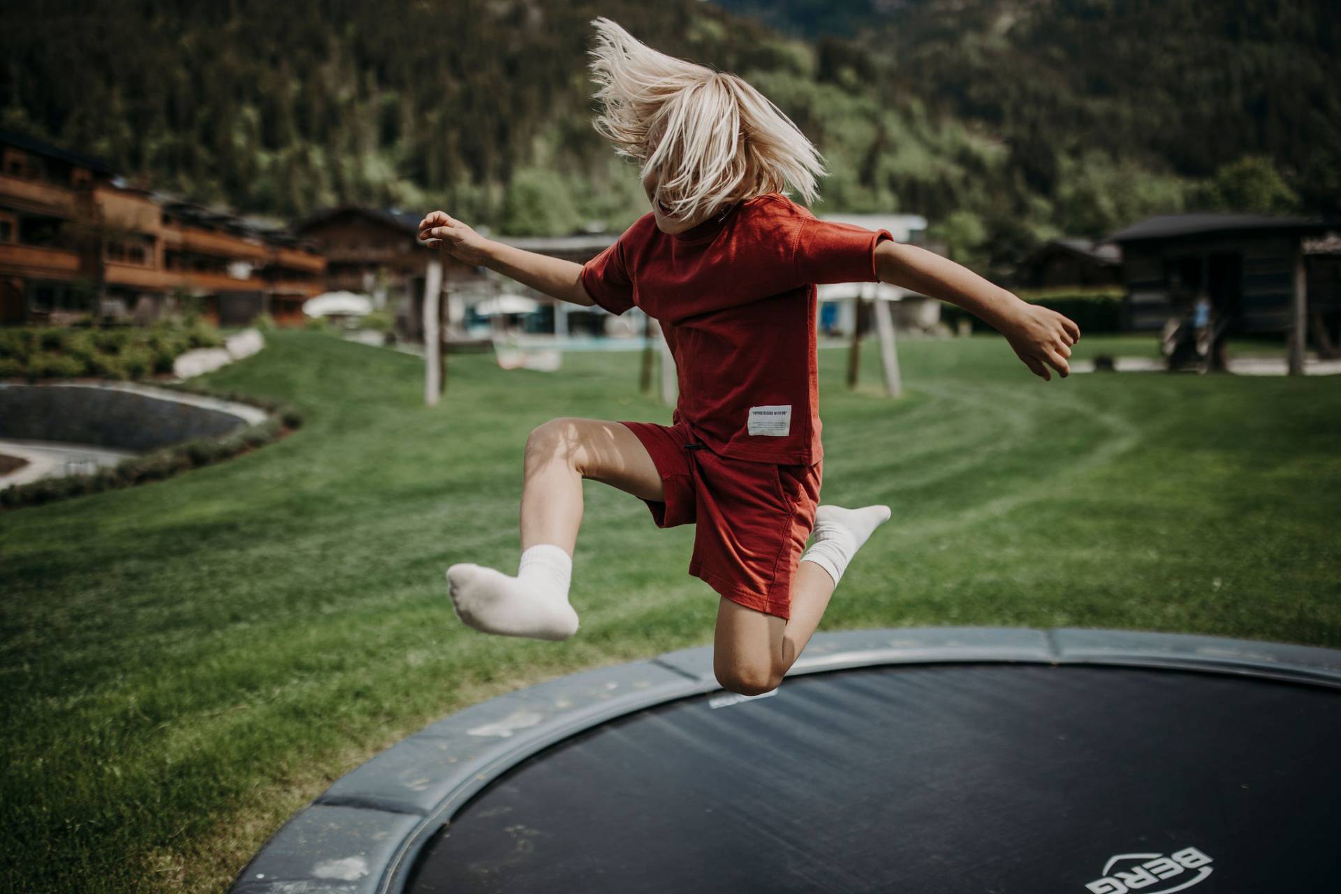 Blondes Kind fährt mit blau-schwarzem Go Kart den Berg hinunter