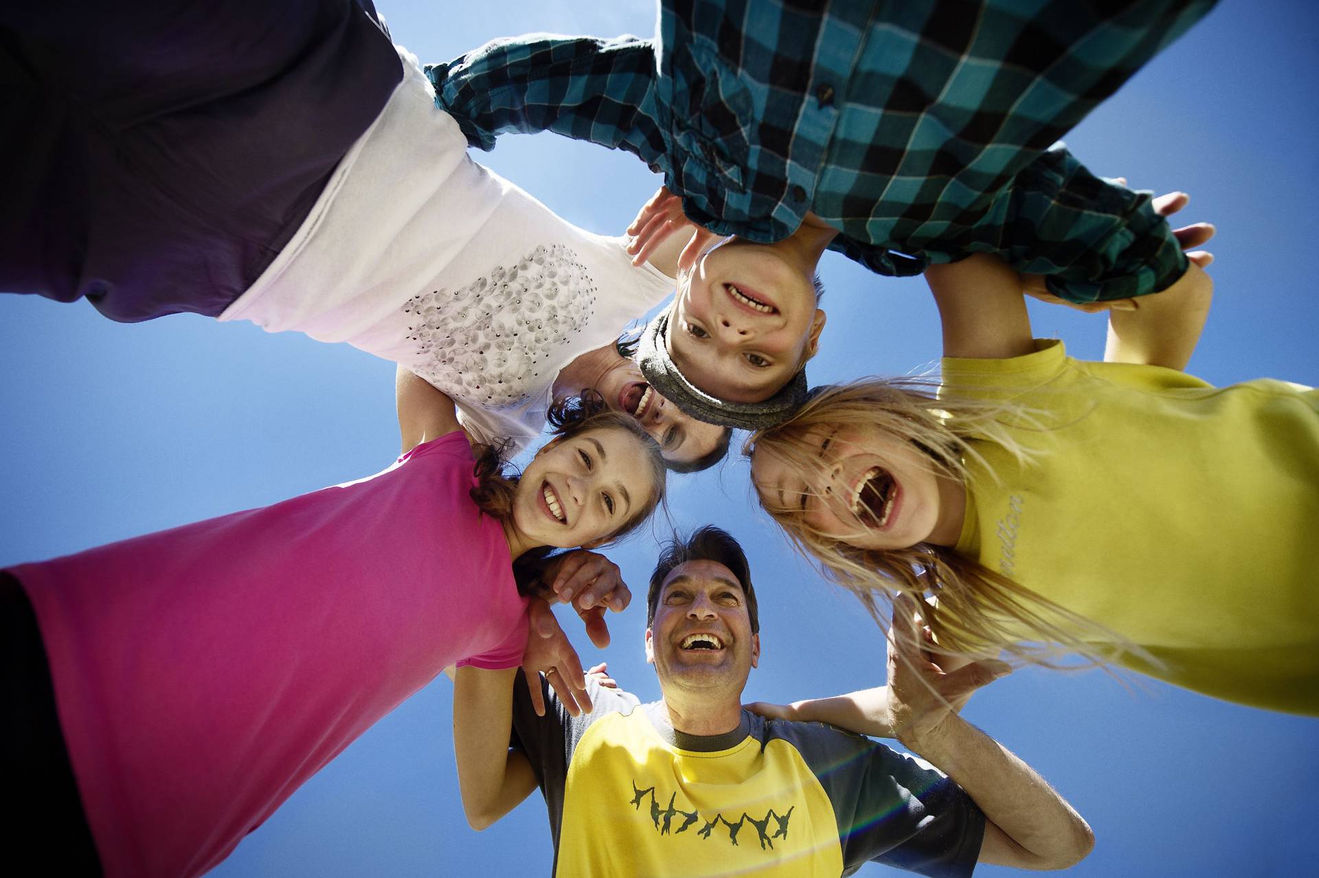 Lachende Familie steht im Kreis - Untersichtperspektive
